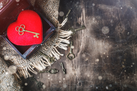 Valentines day background with a heart and an ancient key on wooden table.の写真素材