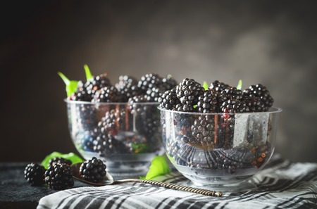 Ripe blackberry on a wooden table. Dark background.の写真素材