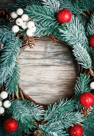 Merry Christmas and happy New year. Christmas decorative wreath on wooden background. Background with copy space. Vertical. Selective focus.の写真素材
