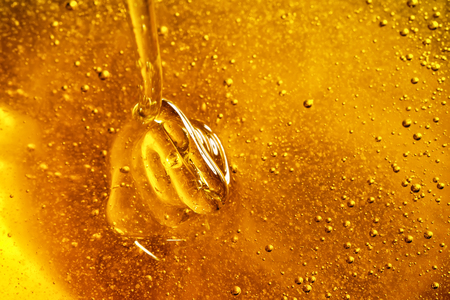 Honey with gold color flows down from a spoon. Healthy food concept.の写真素材
