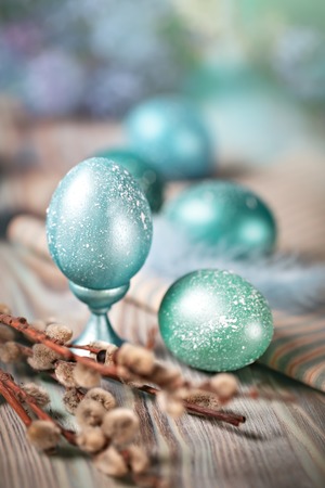 Happy Easter. Congratulatory easter background. Easter eggs and willow branches on a wooden table. Selective focus. Vertical.の写真素材