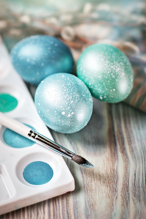 Happy Easter. Congratulatory easter background. Easter eggs and willow branches on a wooden table. Selective focus. Vertical.の写真素材