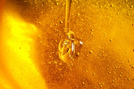 Honey with gold color flows down from a spoon. Healthy food concept. Healthy eating. Diet. Selective focus. Background with copy space.の写真素材