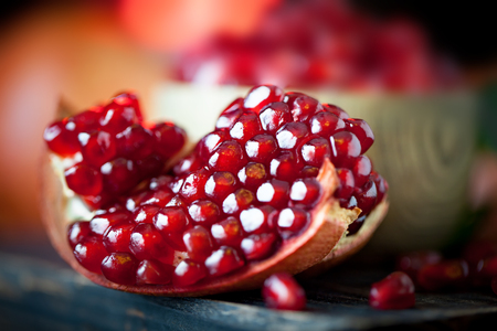 Ripe pomegranate fruit on a old black wooden vintage background. Selective focus.の写真素材