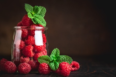 Raspberry. Raspberries and blueberries in a Cup on a dark background. Summer and healthy food concept. Background with copy space. Selective focus.の写真素材