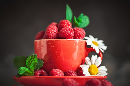 Raspberry. Raspberries in a Cup on a dark background. Summer and healthy food concept. Background with copy space. Selective focus. Horizontal.の写真素材