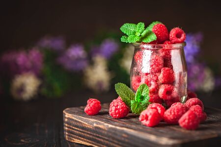 Raspberries in a Cup on a dark background. Summer and healthy food concept. Background with copy space. Selective focus. Vertical.の写真素材