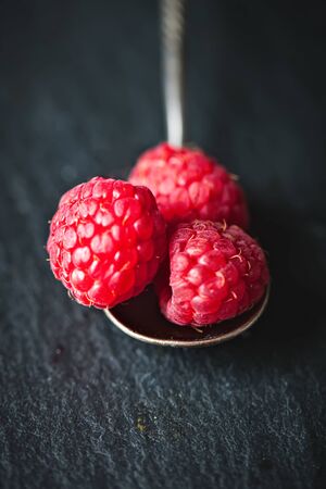 Raspberry on a dark background. Summer and healthy food concept. Background with copy space. Selective focus. Vertical.の写真素材