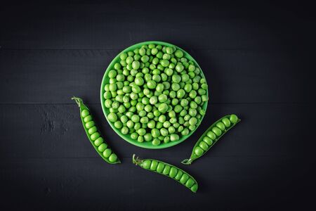 Delicious ripe green peas lying on a wooden table.の写真素材