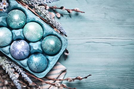 Happy Easter. Congratulatory easter background. Easter eggs and flowers. Background with copy space. Selective focus. Top view.の写真素材