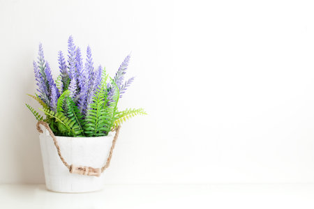 Frame mock up and plants in a vase on on the table. White colors. Greeting card. Background with copy space.の写真素材