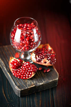 Ripe pomegranate fruit on a old black wooden vintage background. Selective focus.の写真素材
