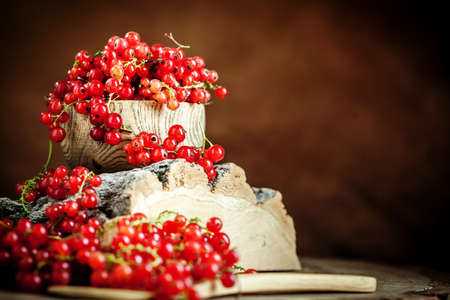 Fresh red currants in a Cup on a dark rustic wooden table. Background with space for copying. Selective focus.の写真素材