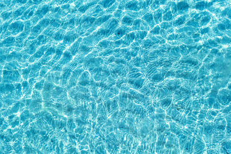 Background shot of aqua water surface. Swimming pool with sunny reflections.の写真素材