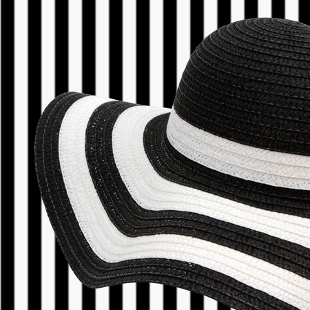 white and black beach hat on striped backgroundの写真素材