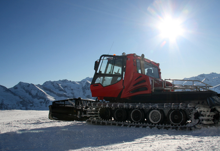 Snow-grooming machine on snow hill ready for skiing slope preparations in Austrian Alps.の写真素材