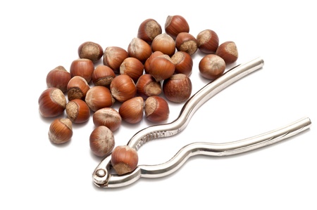 hazelnuts with nutcracker over a white background