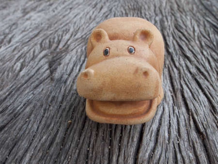 The hippopotamus Pottery for garden decoration sit on the old wood tableの写真素材