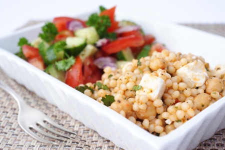 Couscous feta cheese and chickpeas salad with tomatoes, cucumbers and onionsの写真素材