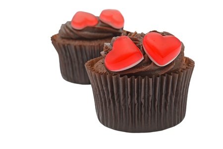 Chocolate cupcakes with red heart shaped jelly sweets isolated on whiteの写真素材