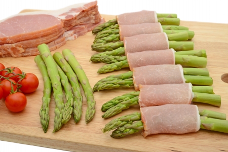 Food preparation  bacon wrapped asparagus on cutting board uncookedの写真素材