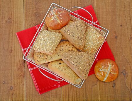 bread rolls in basket on the table wtih red napkinの写真素材