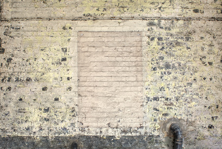 weathered grunge old painted brick wall with pipesの写真素材