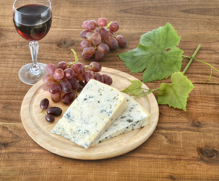 Cheese, grapes and wine on woodの写真素材