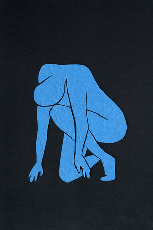 Cut-out blue paper male figure on black backgroundの写真素材