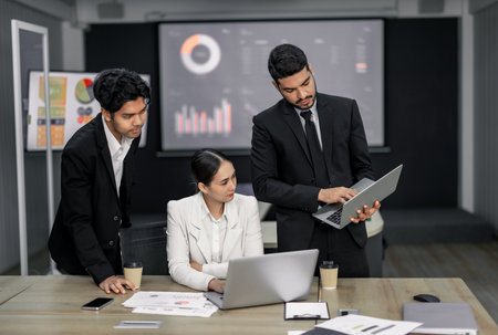 Financial advisors collaborate to assess a company's financial performance using data from its operational activities. Team members work together in a discussions meeting to develop a business plan.の写真素材