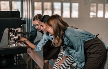 Young adult coffee makers work with skilled baristas to create menus. Using a coffee machine to make hot and cold coffee. Experiment with grinding and blending, including adding milk foam on top.の写真素材