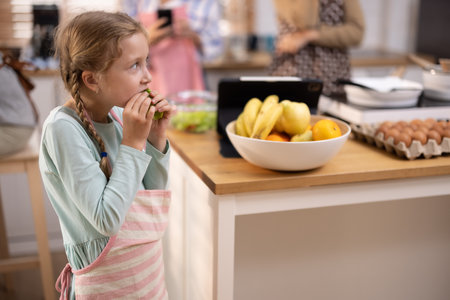 Multi-generational family members explore new and tasteful recipes on a tablet, make healthy food choices, cook, and enjoy meals together. Family gatherings help renew and strengthen relationships.の写真素材