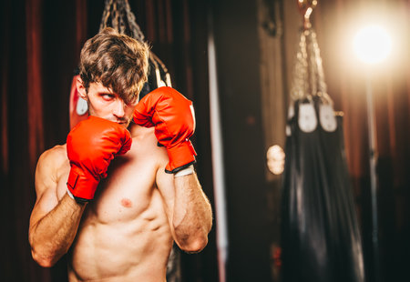Boxers at the professional level routinely train by punching and kicking sandbags. To be successful in the individual's career, self-discipline, determination, and patience are essential qualities.の写真素材