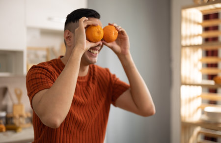 A homely and healthy male prepares nutritious diet, including variety of fruits. Following cooking show on laptop Mastery of peeling, chopping, and slicing fruits to prepare them in artistic style.の写真素材