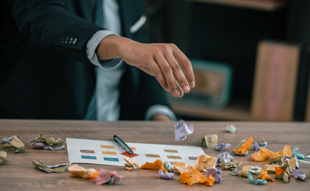 After having difficulties with project's actual implementation, designers feel stress and concern, which causes them to angrily crumple some sticky notes, that contained a number of different ideas.の写真素材