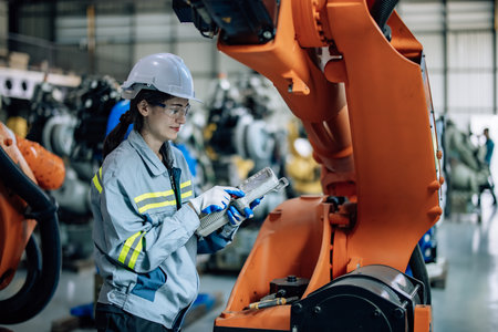 Robotic technician uses control panel to operate, maintain robotic arm in factory. Ensuring productivity, efficiency, and safety through monitoring, analyzing database, and integrating processes.の写真素材