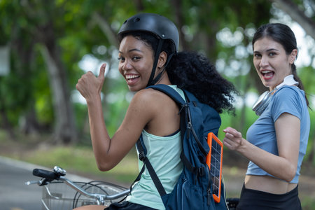 Female cyclist combine eco-consciousness with active lifestyle, using bikes for workout and travel, a portable solar panel for device charging, and embracing recycling practices for circular economy.の写真素材