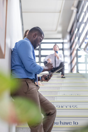 A joyful group of multicultural colleagues, filled with optimism and friendship, engage in easy, authentic conversation after completing project. Selfie, celebrating their successful teamwork.の写真素材