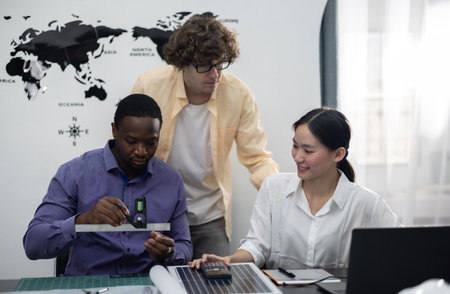 Architect and interior designer collaborate on a low carbon building master plan, using precision tools to measure, mark dimensions, and create a detailed mock-up model for LEED certification approvalの写真素材