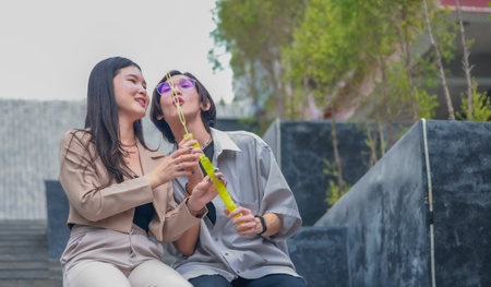 Asian lovers engage in playful interactions outdoors. Their eyes meet with affectionate gaze,...