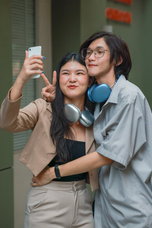 Asian lovers engage in playful interactions outdoors. Their eyes meet with affectionate gaze, radiating love and tenderness. Laughing and sharing intimate moments filled with warmth and playfulness.の写真素材