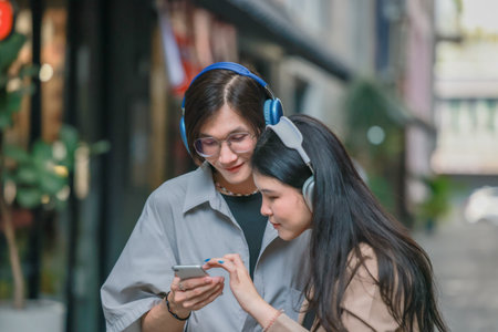 Asian lovers engage in playful interactions outdoors. Their eyes meet with affectionate gaze,...