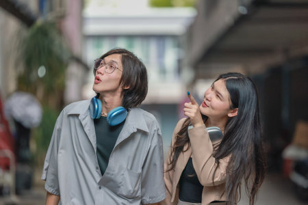 Asian lovers engage in playful interactions outdoors. Their eyes meet with affectionate gaze, radiating love and tenderness. Laughing and sharing intimate moments filled with warmth and playfulness.の写真素材