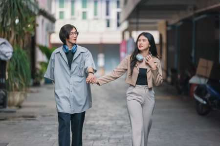 Asian lovers engage in playful interactions outdoors. Their eyes meet with affectionate gaze, radiating love and tenderness. Laughing and sharing intimate moments filled with warmth and playfulness.の写真素材