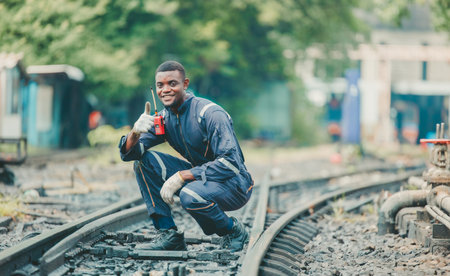The locomotive maintenance engineer, dressed in safety gear, inspects the railway track for signs of wear and proper alignment. Focus on detail and precision. Ensuring it meets all safety standards.の写真素材