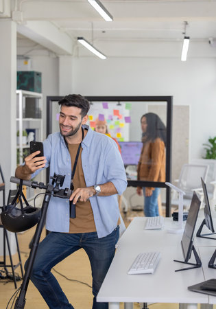 Startup team member arrives at office on scooter, preparing to join meeting with colleagues. Capturing modern, dynamic work culture and eco-friendly transportation choices of young professional teamの写真素材