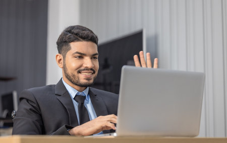 Professional businessperson in a suit is deeply focused on laptop in a modern office. Concentration and seriousness for corporate work environments and business decision-making scenarios.の写真素材