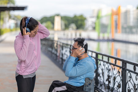 A couple enjoys an outdoor moment, listening to music with headphones while selecting a playlist on...