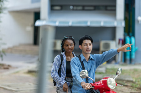 Two young professionals commute together on an electric motorcycle, promoting sustainable and eco friendly travel in an urban setting. The image highlights modern transportation and teamwork.の写真素材
