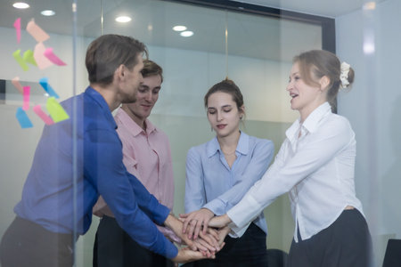 Group of professionals in office celebrating achievements with applause and smiles. Positive atmosphere reflects teamwork, motivation, success, highlighting collaboration and workplace appreciation.の写真素材